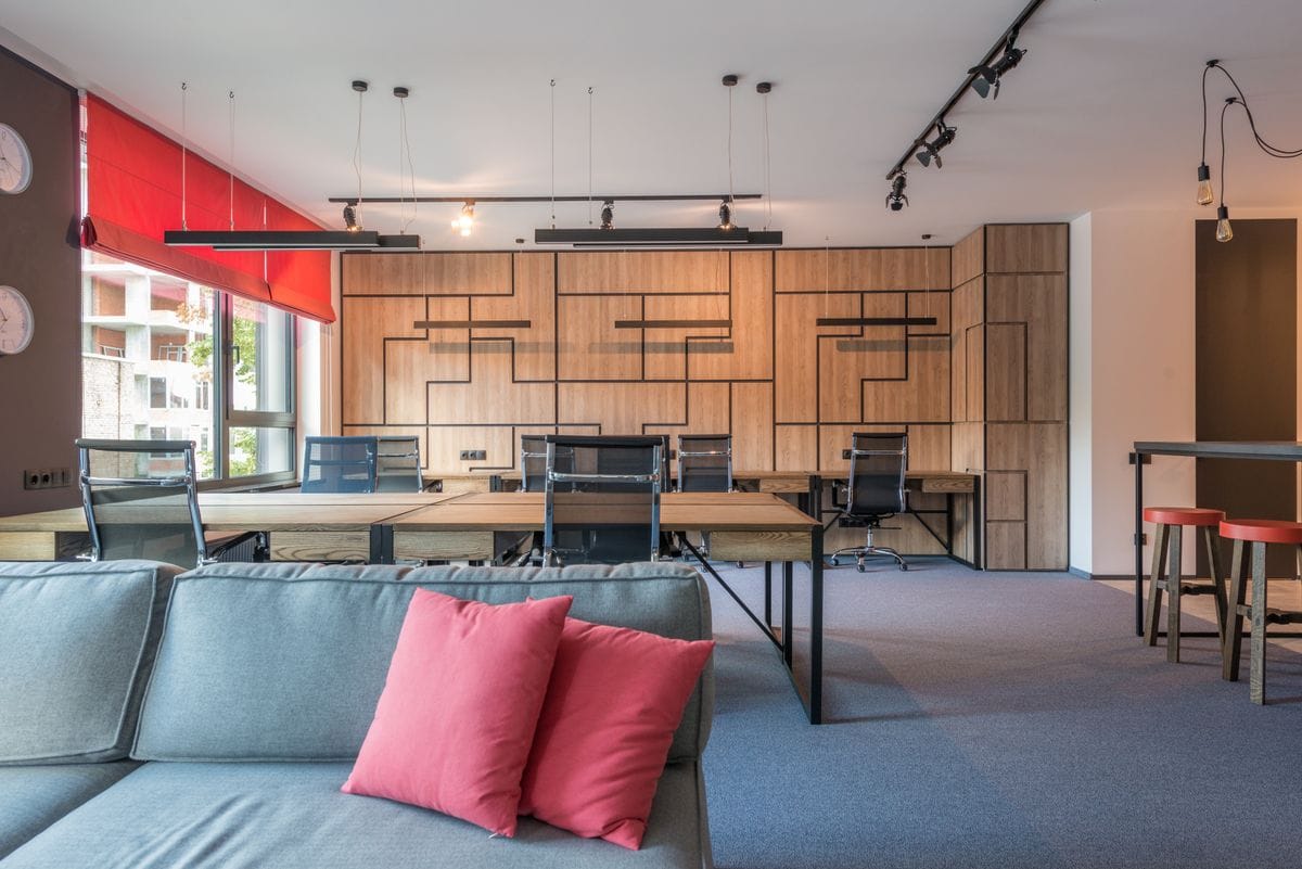 Open workspace with wood panelling, a sofa and pendant lights